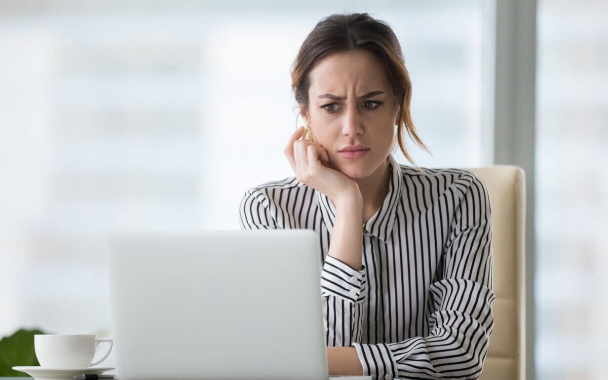 Confused woman looking at laptop