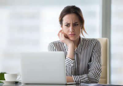 Confused woman looking at laptop